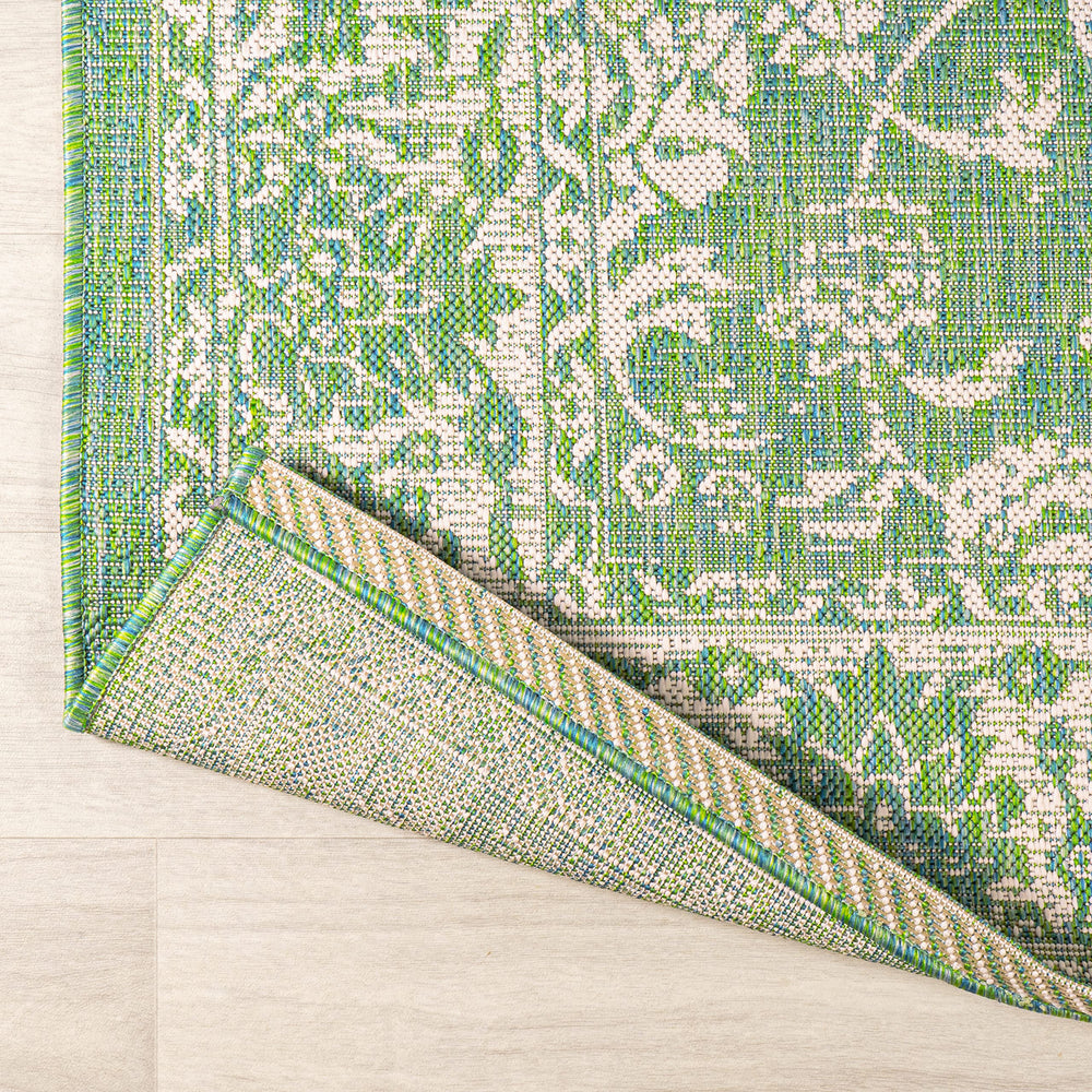 Lifestyle image of JONATHAN Y Weave Floral Runner Rug in a garden setting