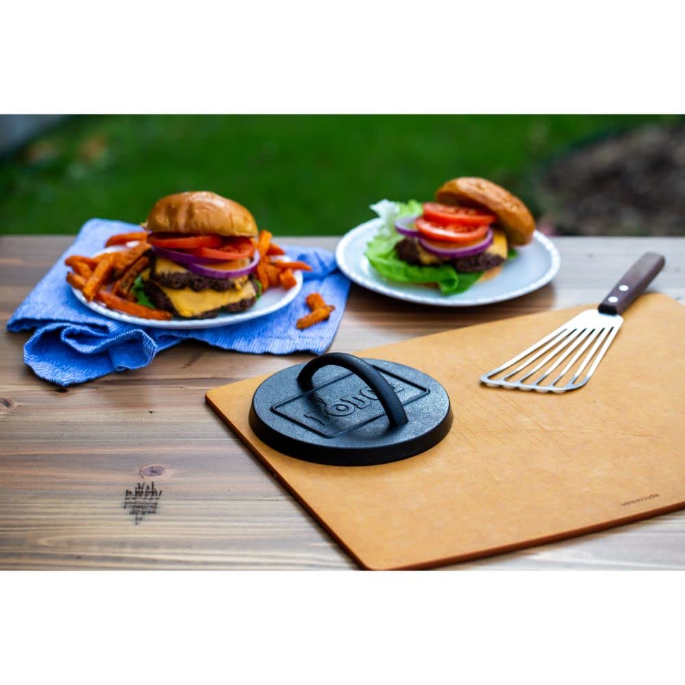 Lodge cast iron burger press displayed with grilling tools
