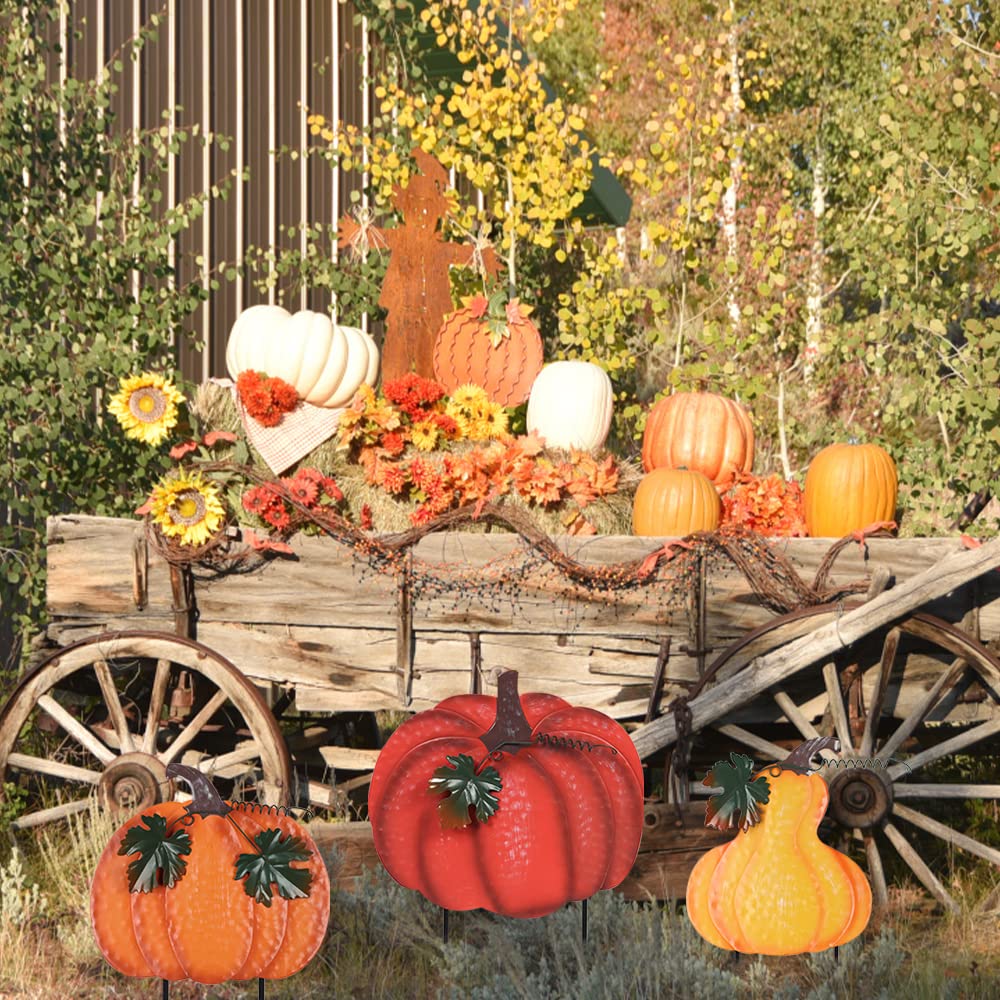 metal pumpkin garden stakes in a flower bed