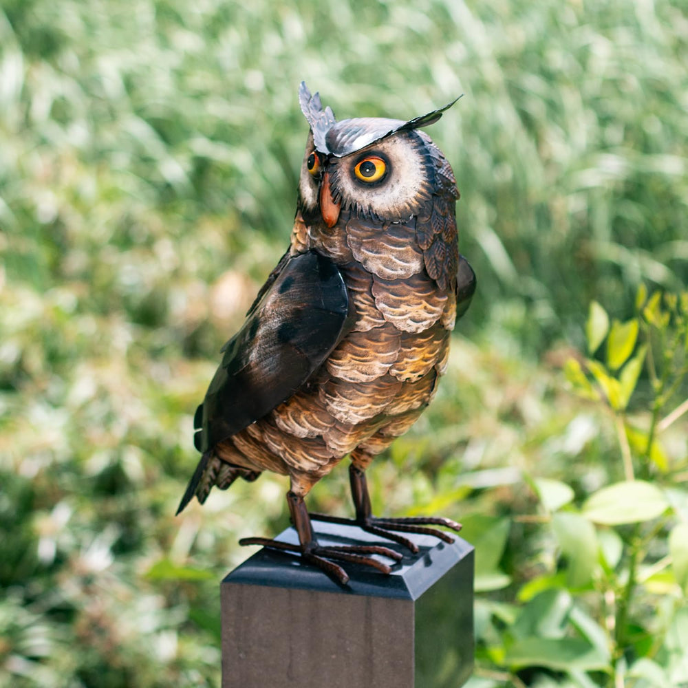 Natelf Owl Statue in a patio with flowers around