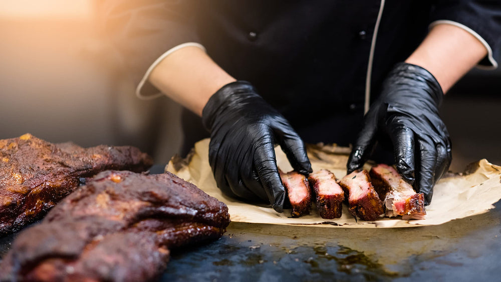 Nechtik BBQ Gloves displayed with a grill