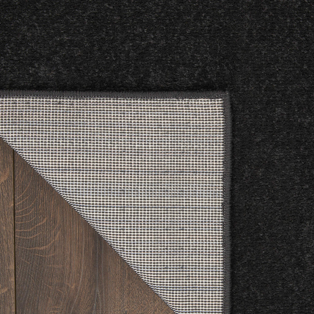 Nourison Essentials Black Runner Rug in an outdoor patio setting