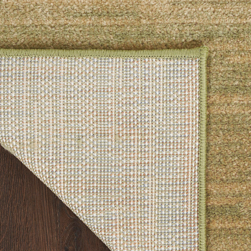 Nourison Essentials Green Gold Outdoor Rug layered with patterned rug