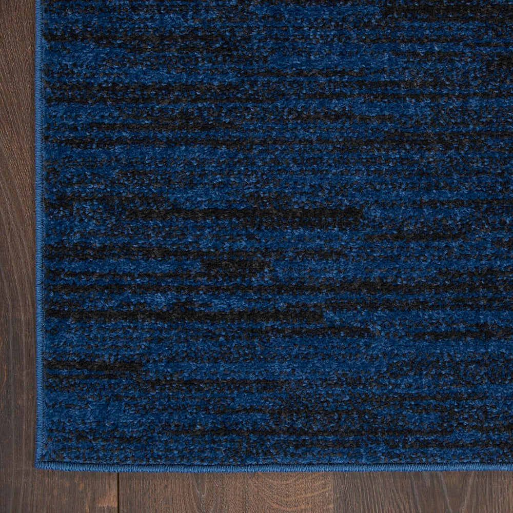 Nourison Essentials Midnight Blue Area Rug layered with patterned rug