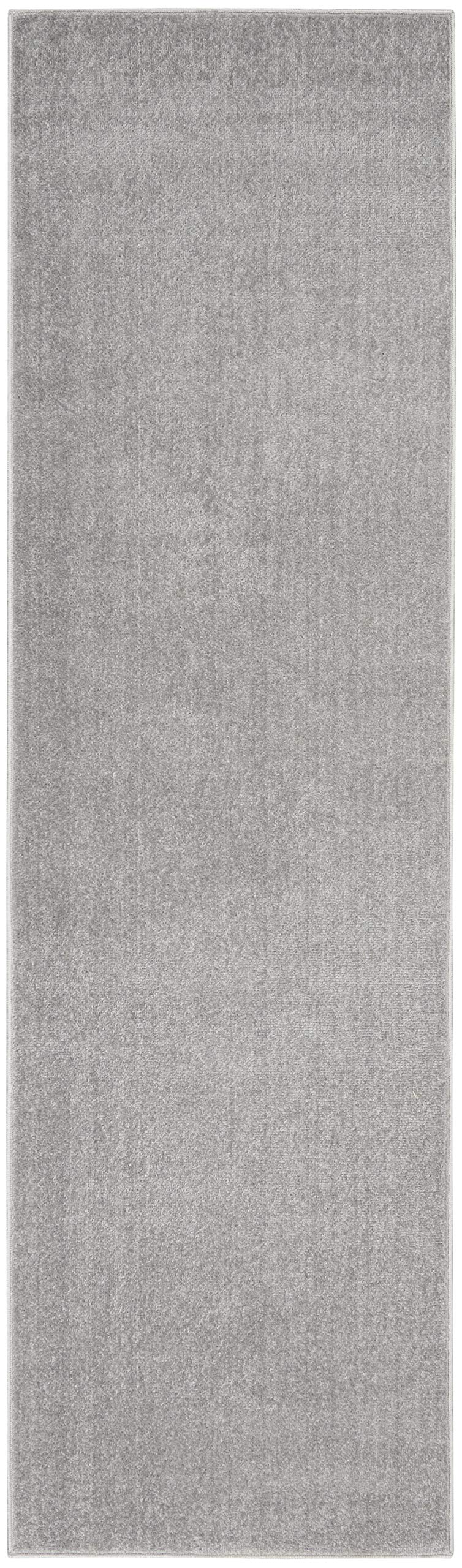 Nourison Essentials Outdoor Rug 2' x 6' layered with patterned rug