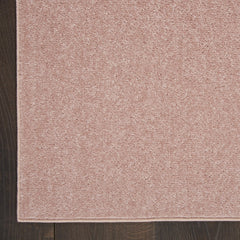 Nourison Essentials Pink Area Rug in outdoor patio setting