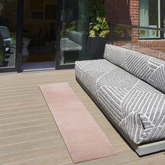 Nourison Essentials Pink Outdoor Rug in living room setting