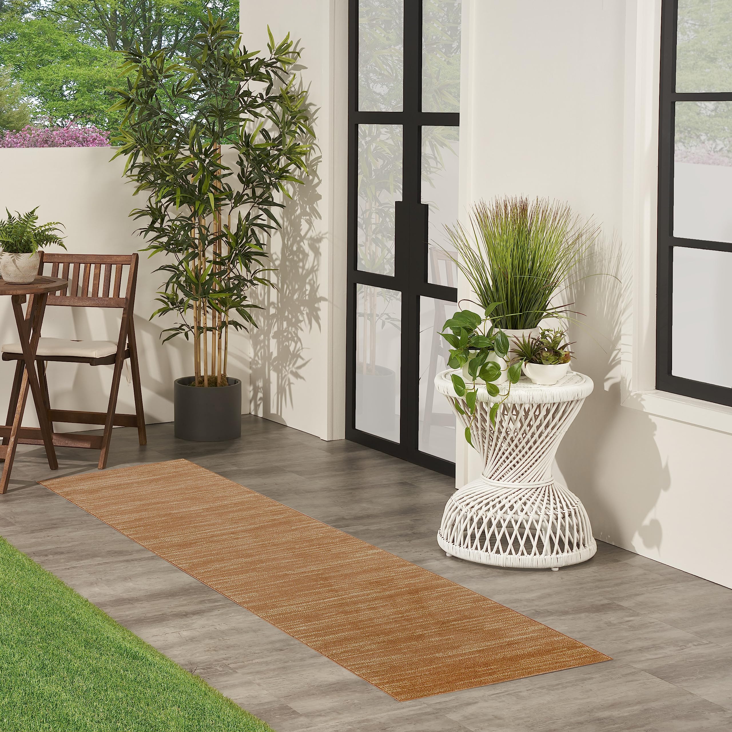 Nourison Essentials Rust Outdoor Rug in a living room setting