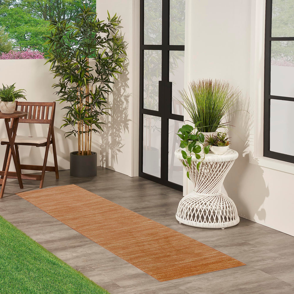 Nourison Essentials Rust Outdoor Rug in a living room setting