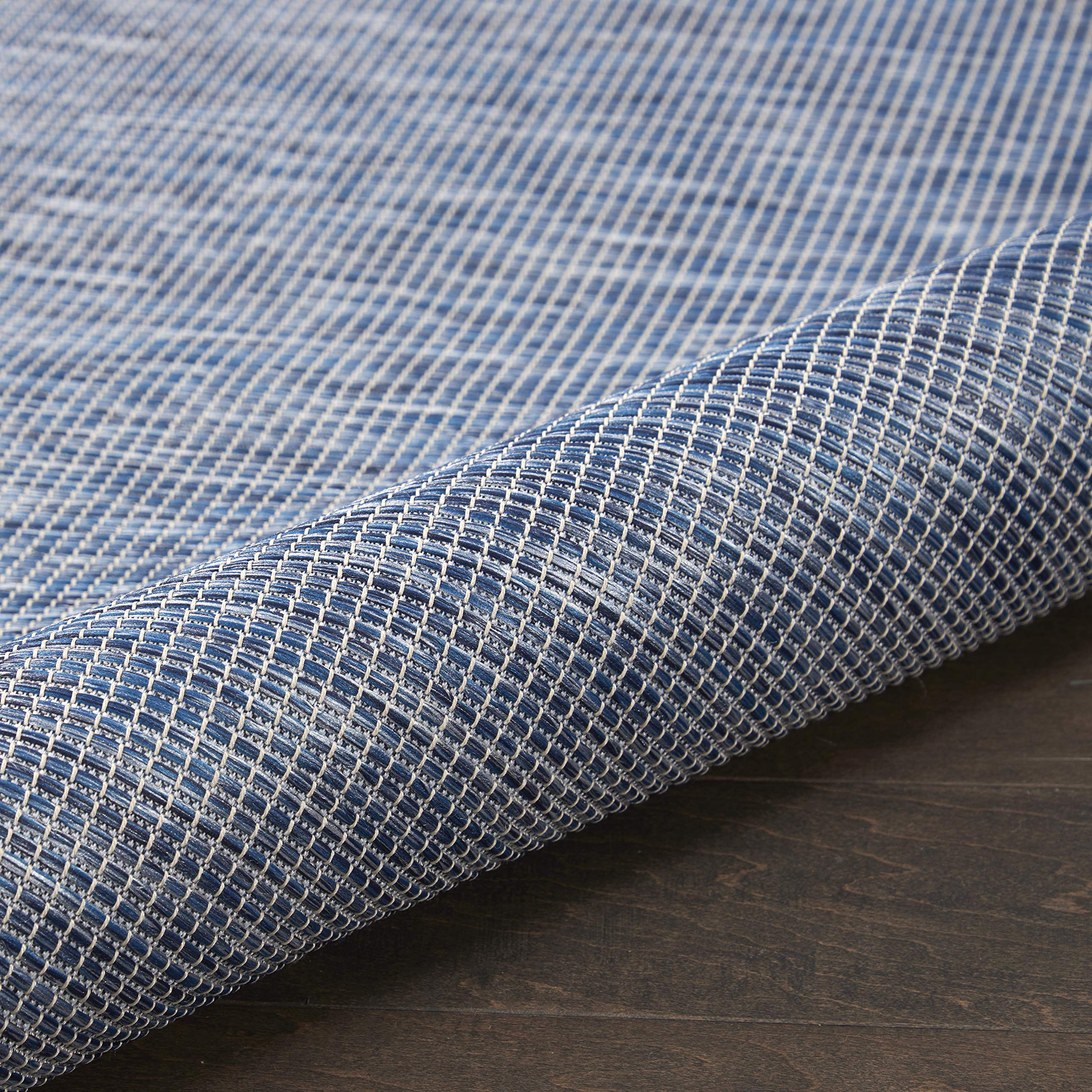 Nourison Positano Navy Blue outdoor rug layered with patterned rugs