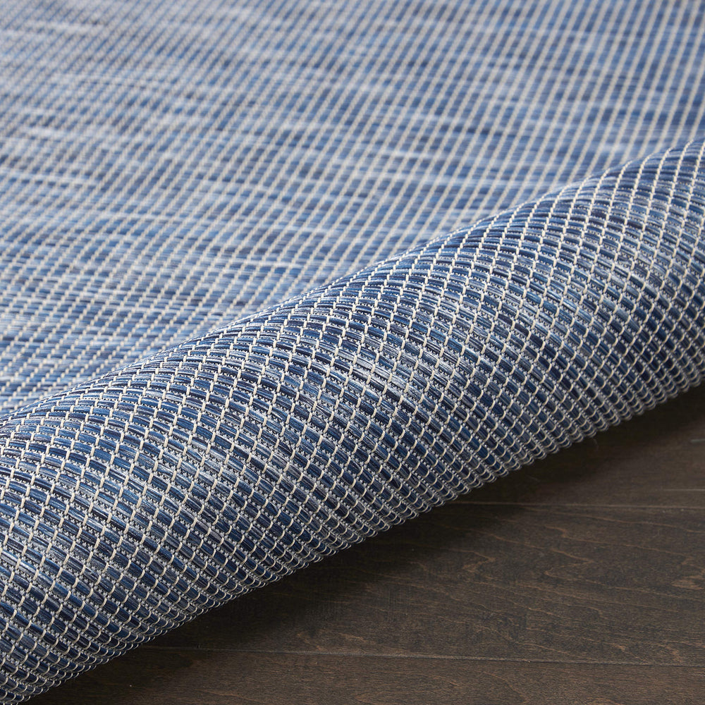 Nourison Positano Navy Blue outdoor rug layered with patterned rugs