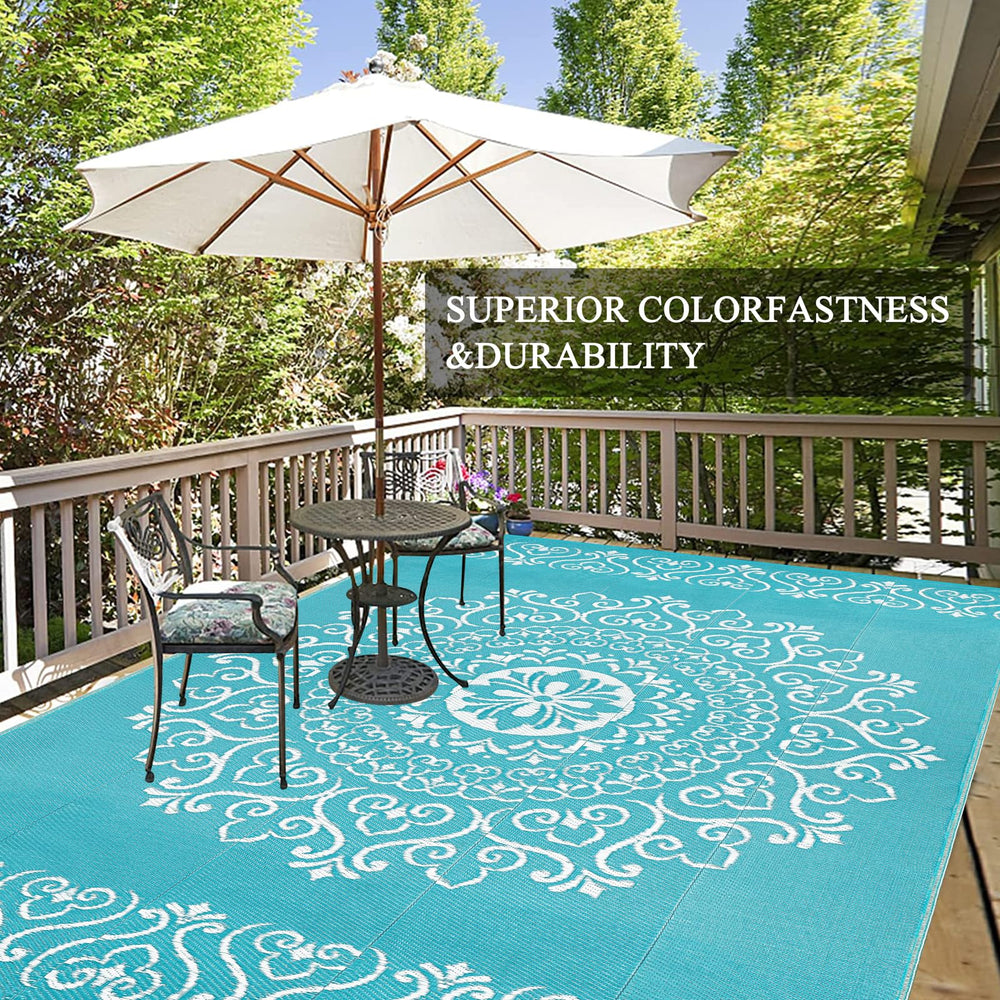 Pauwer Outdoor Rug 9x12 Floral Teal displayed on patio