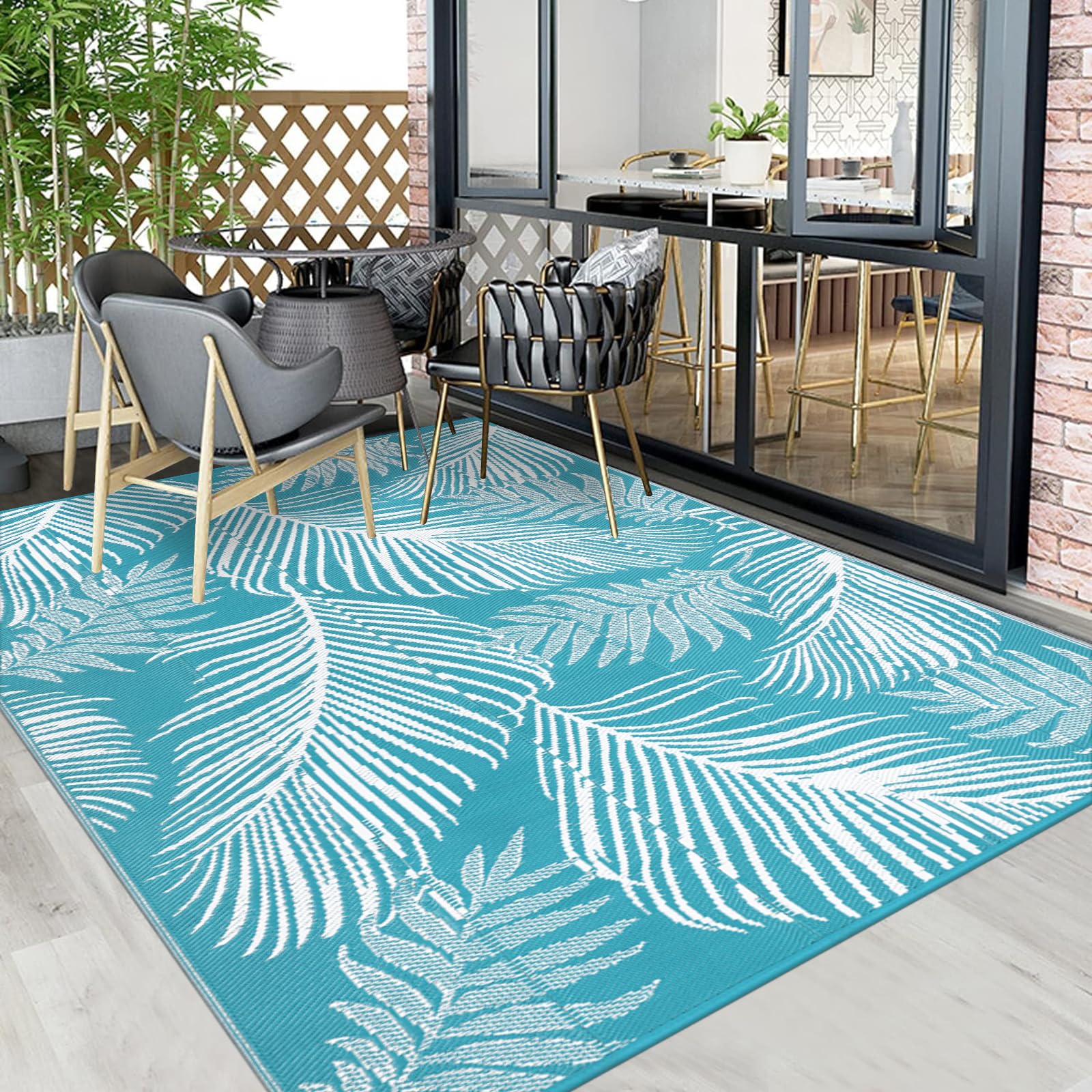 Pauwer Outdoor Rug Leaf Teal laid out on a beach