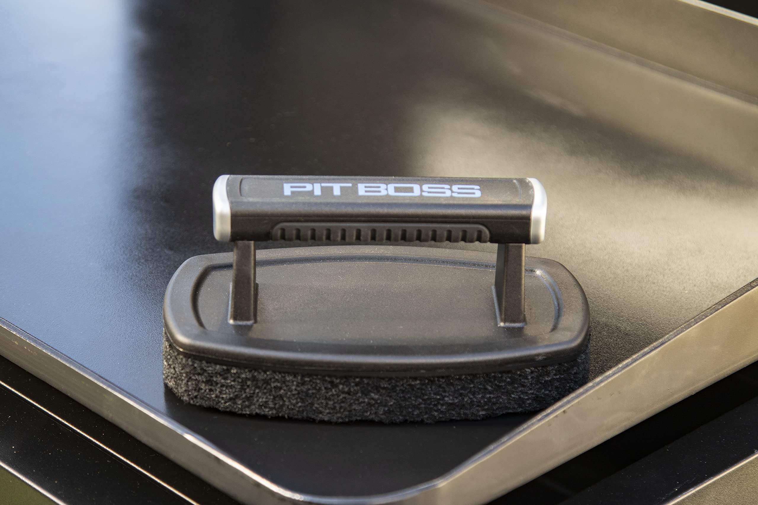 PIT BOSS Griddle Cleaning Brush showing the plastic handle and scouring pad