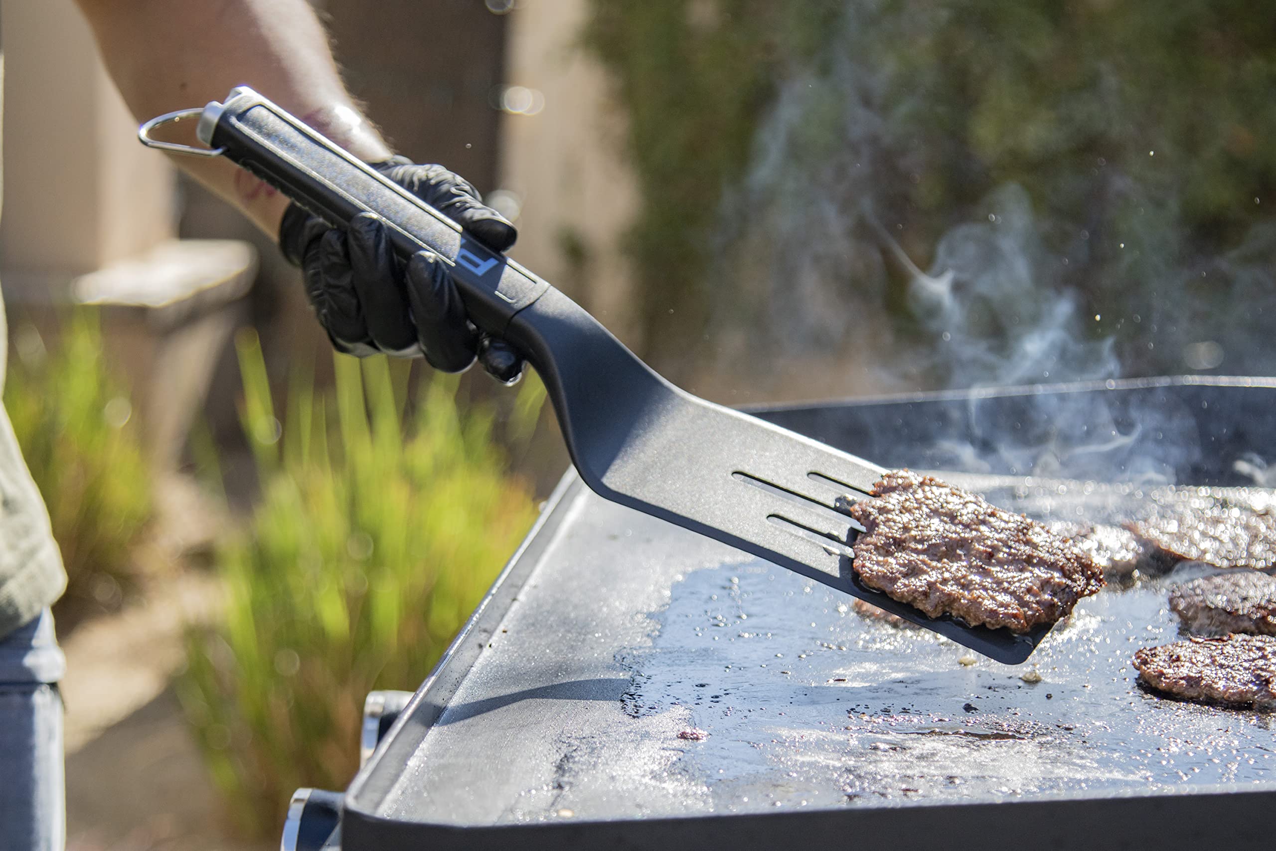 PIT BOSS griddle scraper demonstrating its chopping capability