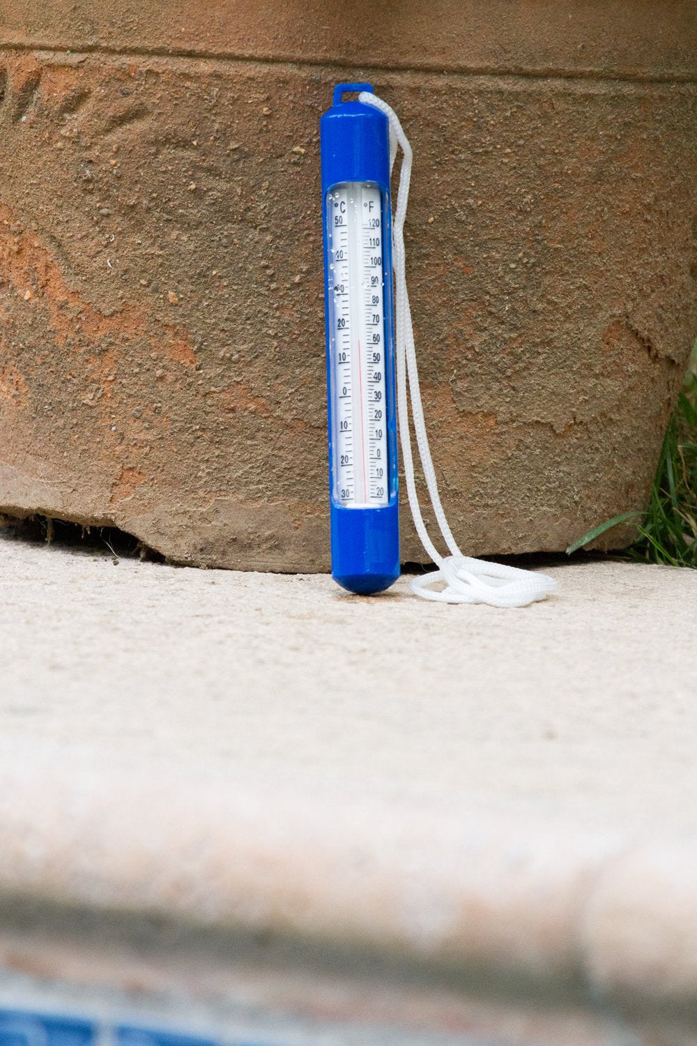 Poolmaster thermometer floating in a pool, displaying temperature