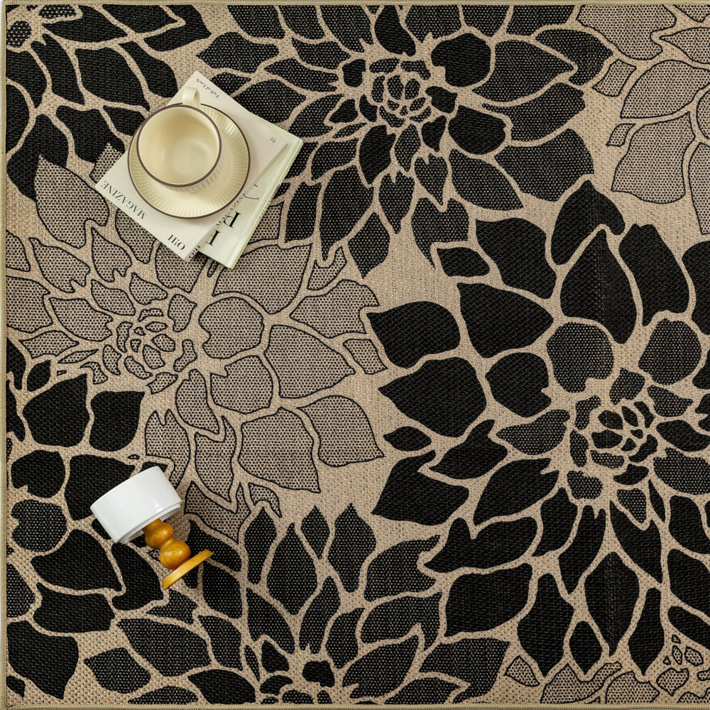 PureCozy 5x8 Black Outdoor Rug rolled up for storage
