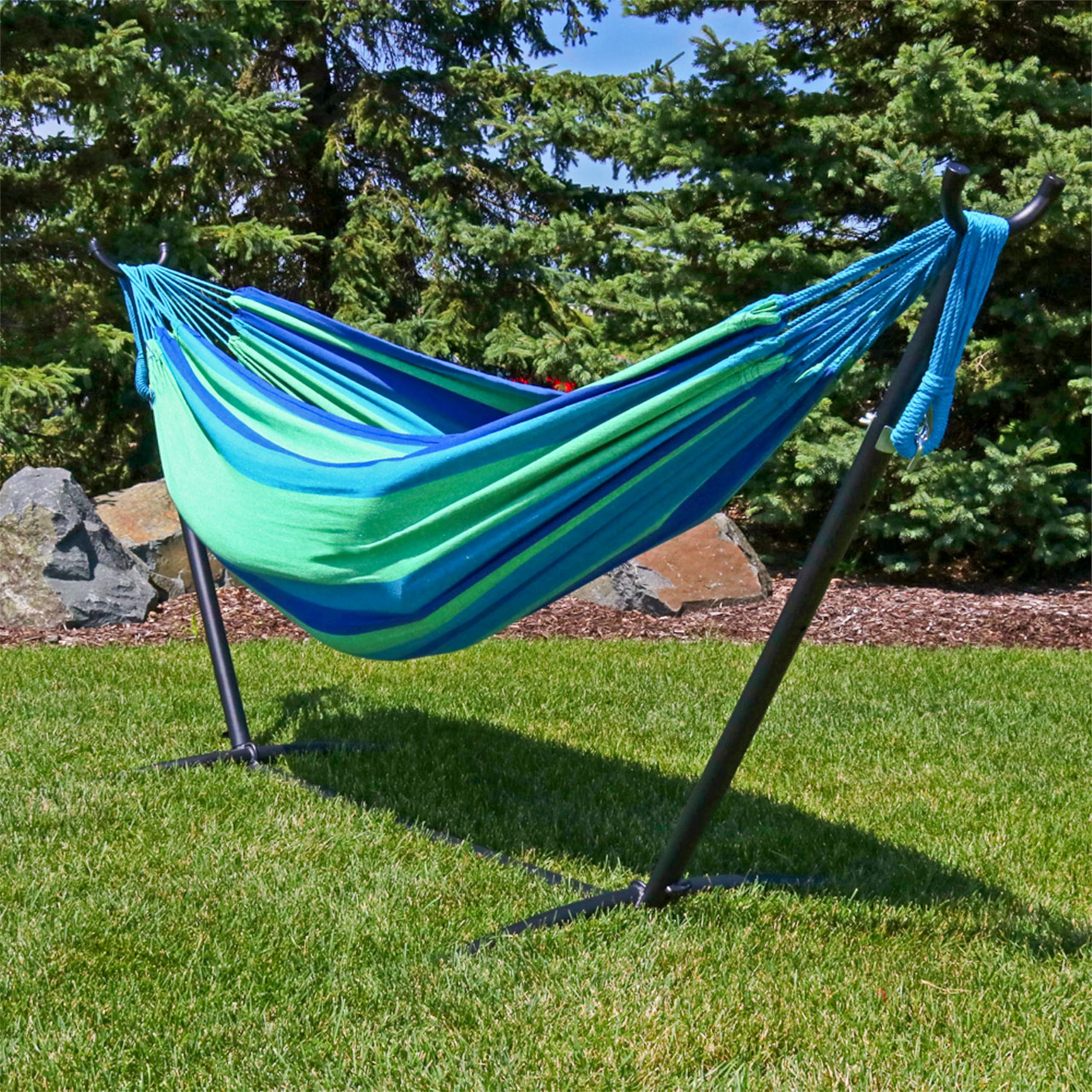 Sunnydaze Brazilian Double Hammock set up between trees in a park