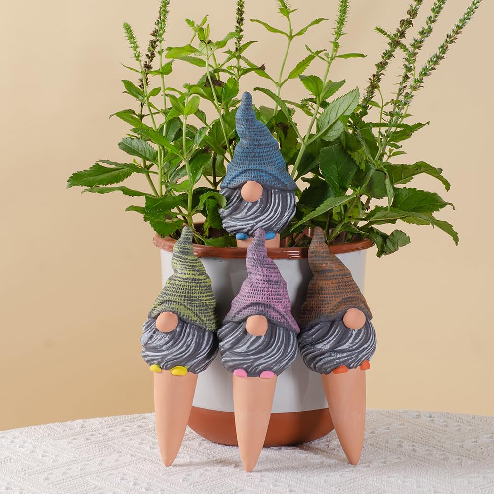 Terracotta watering spike inserted into soil of a potted plant