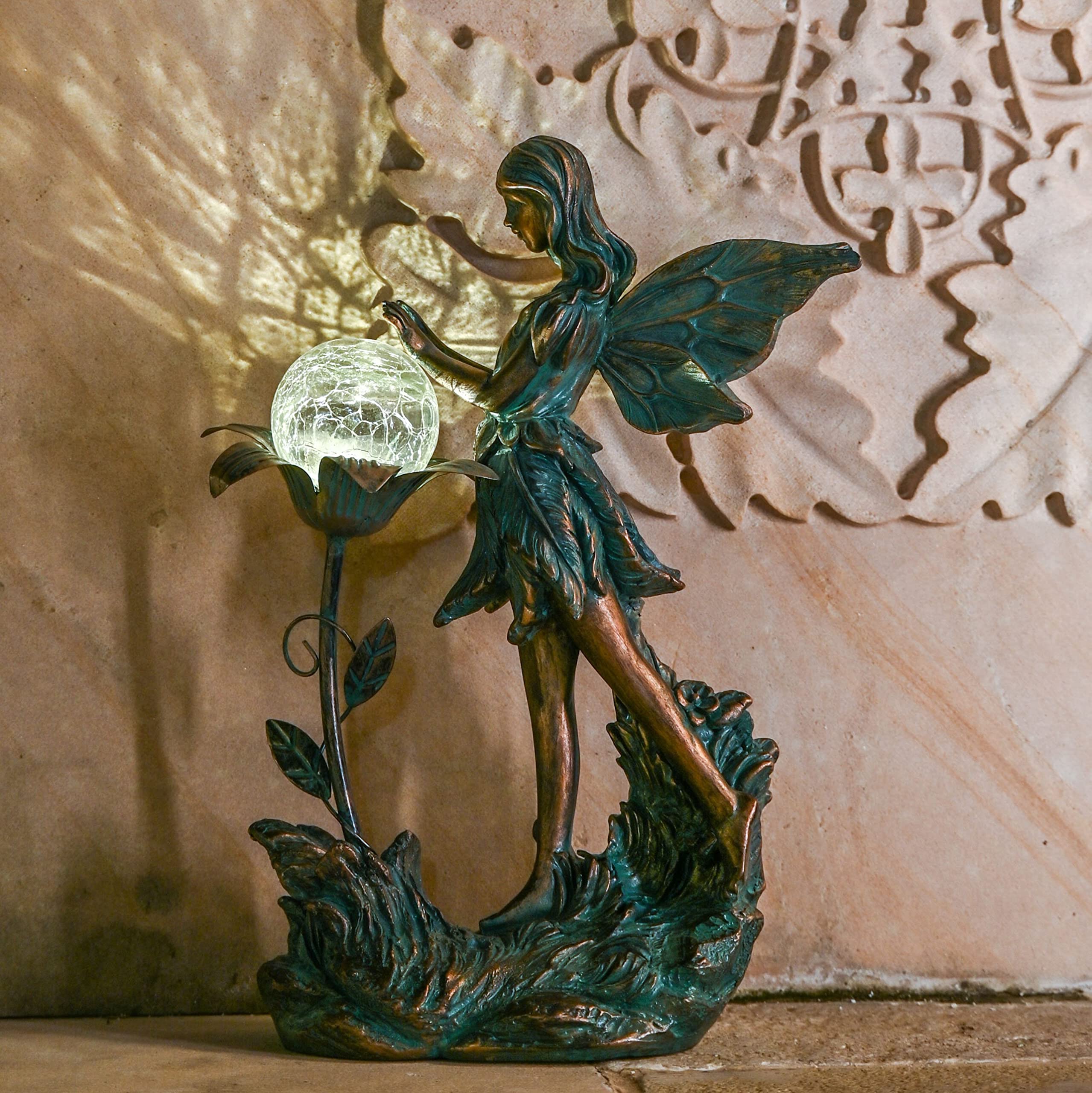 The garden fairy statue among flowers in a garden bed