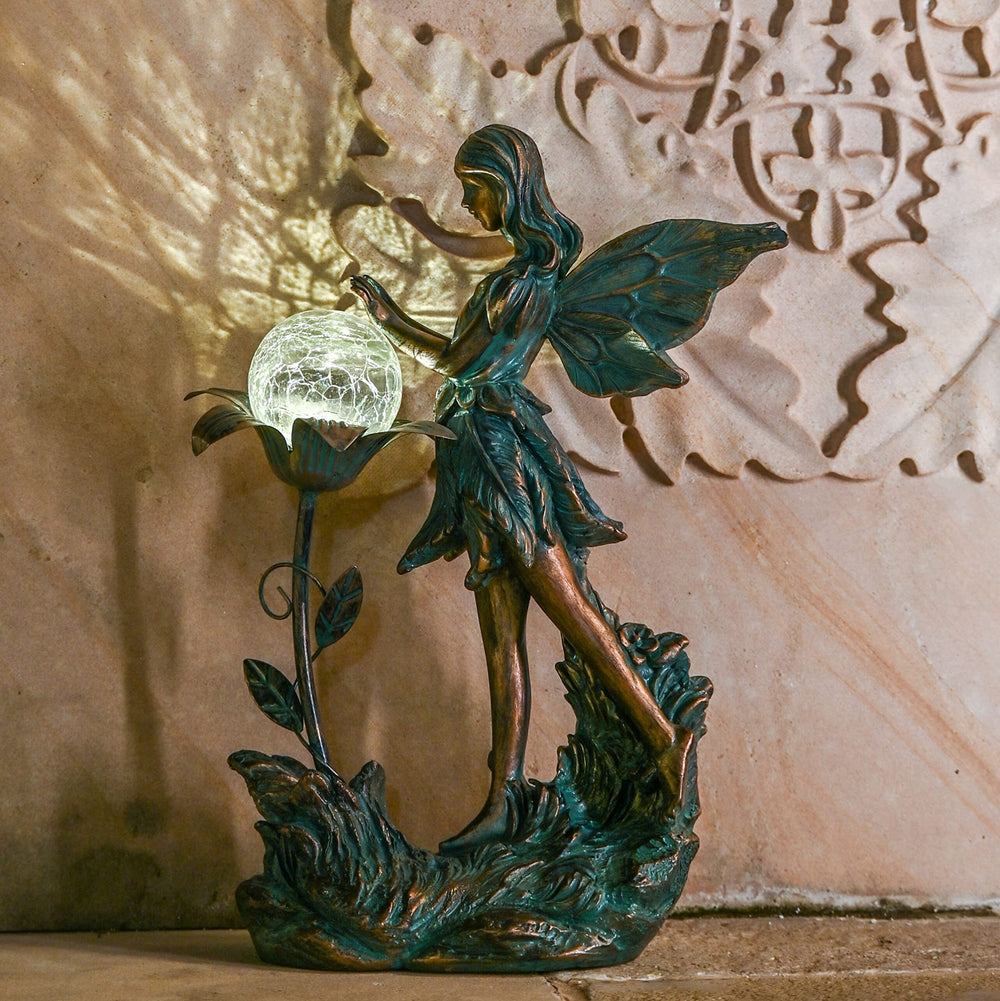 The garden fairy statue among flowers in a garden bed