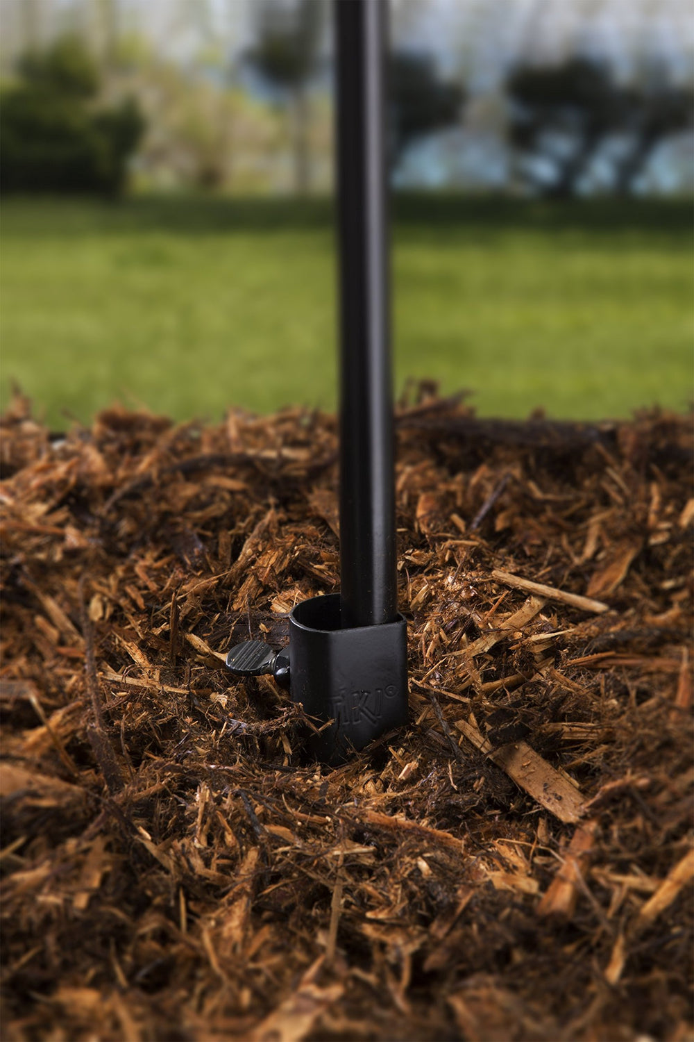TIKI Torch Stake installed in yard holding a torch