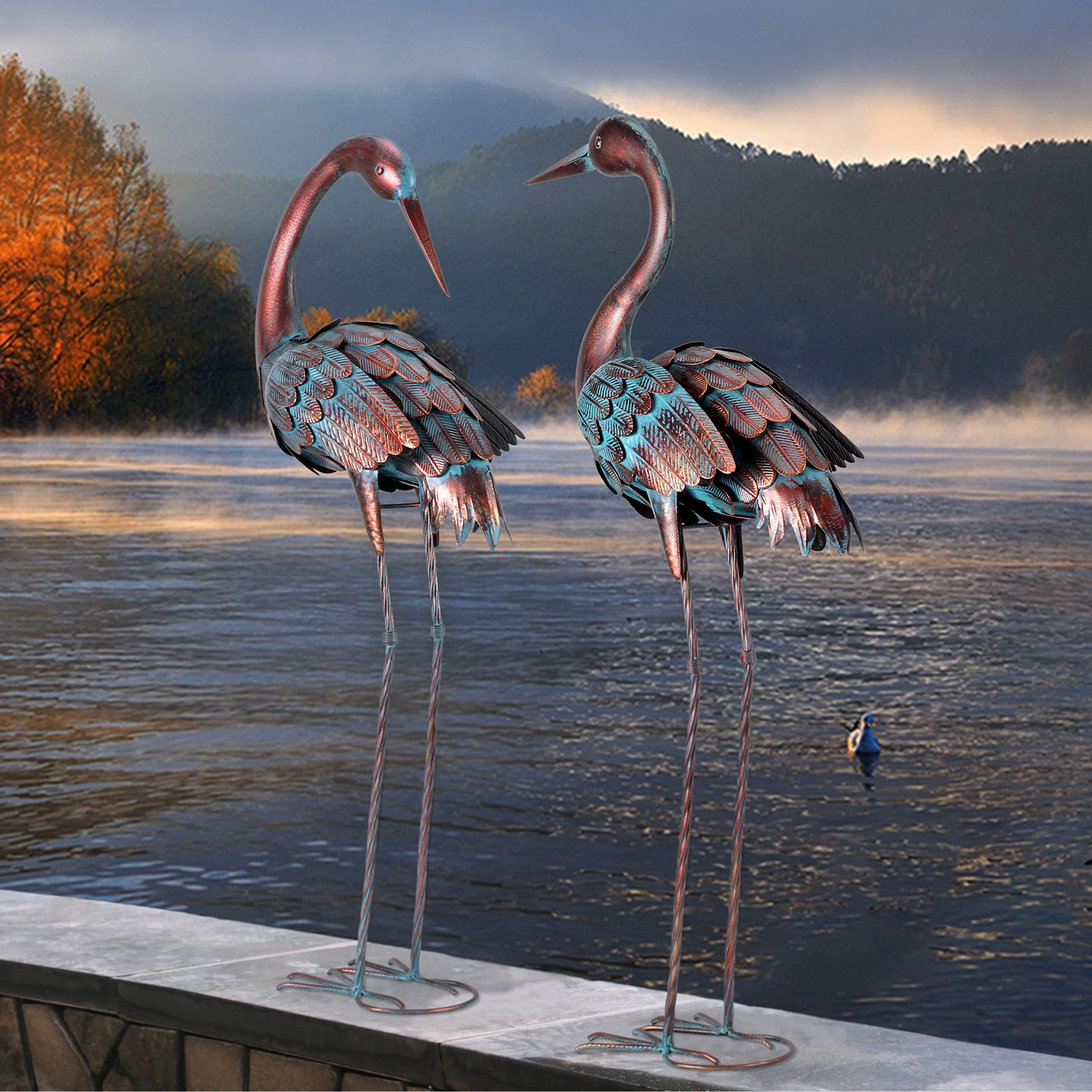 two chisheen crane garden statues in a landscaped garden