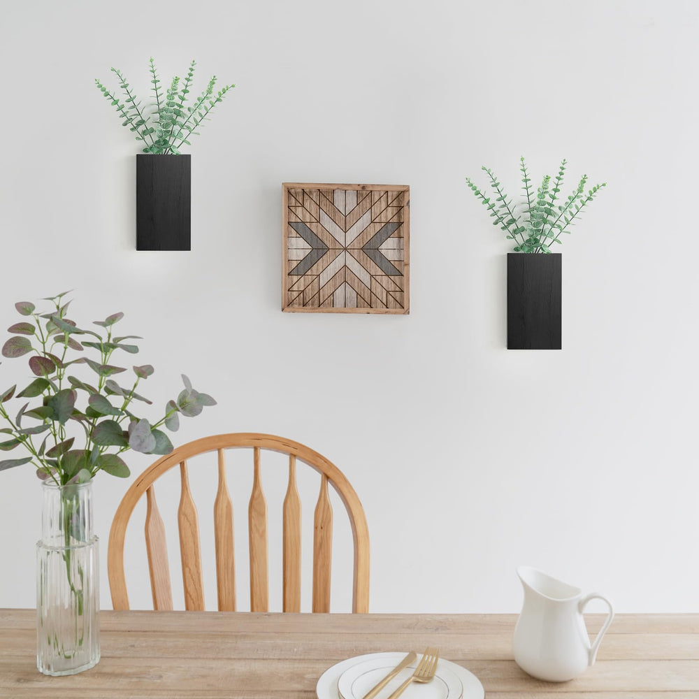Two Dahey wall planters with fake eucalyptus on a white wall
