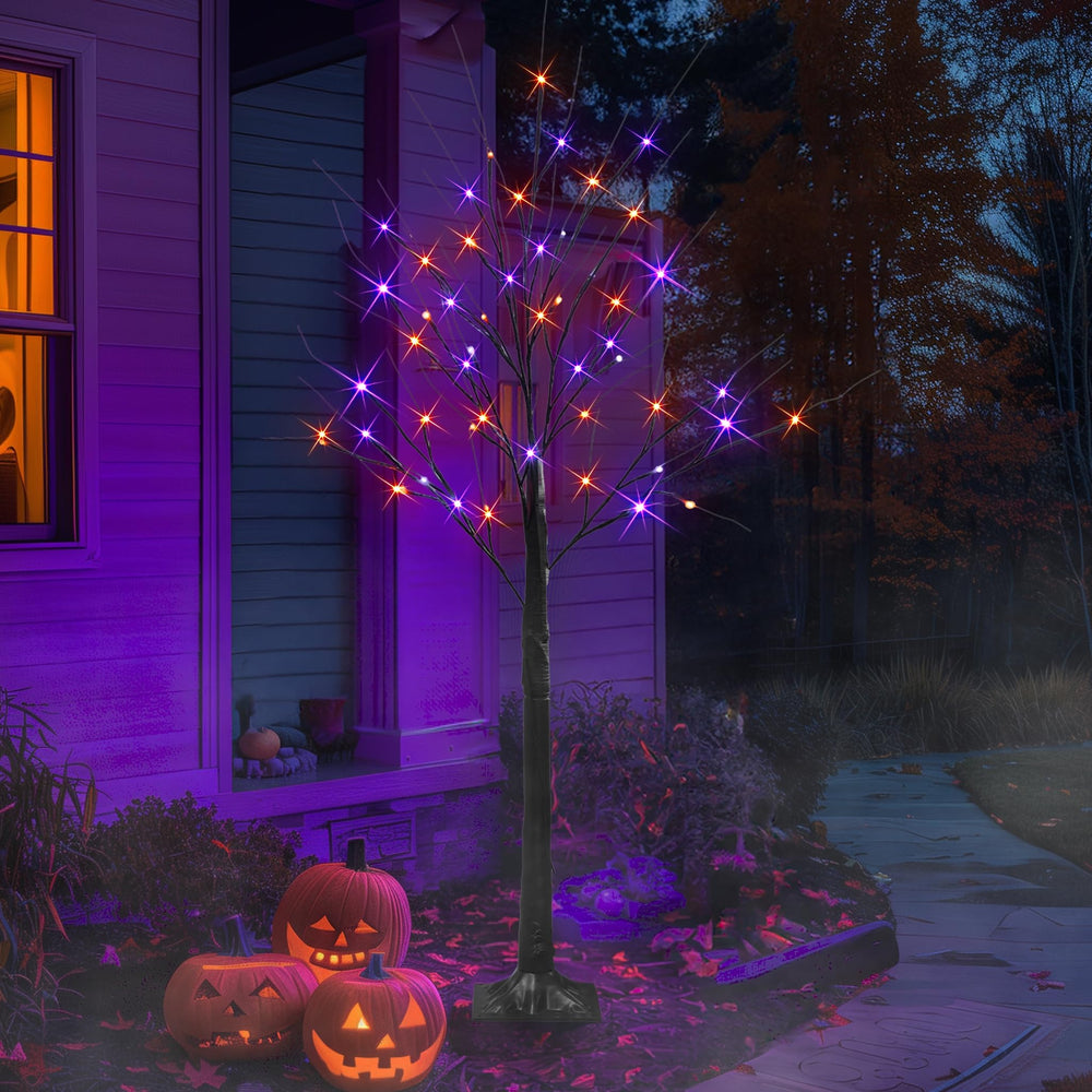 Two Dazzle Bright 4FT Halloween birch trees in a garden setting