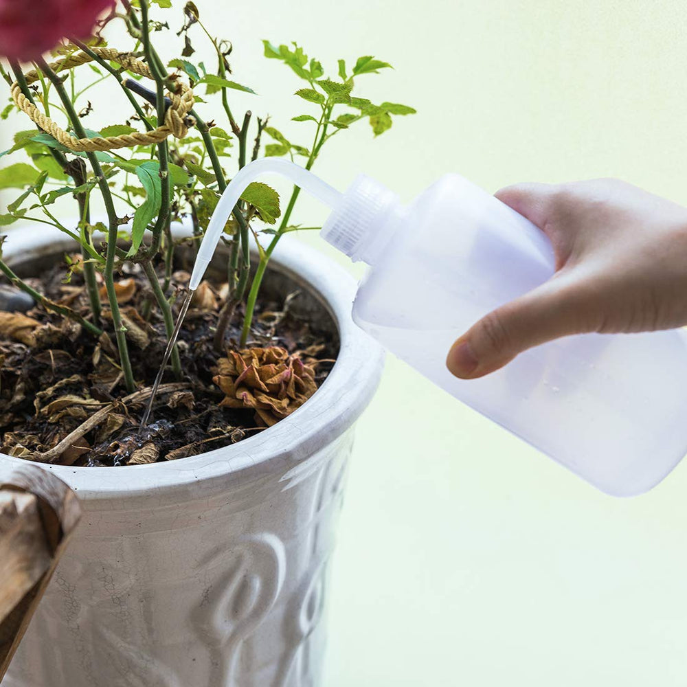 Two Oubest watering bottles in a garden setting