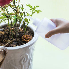 Two Oubest watering bottles in a garden setting