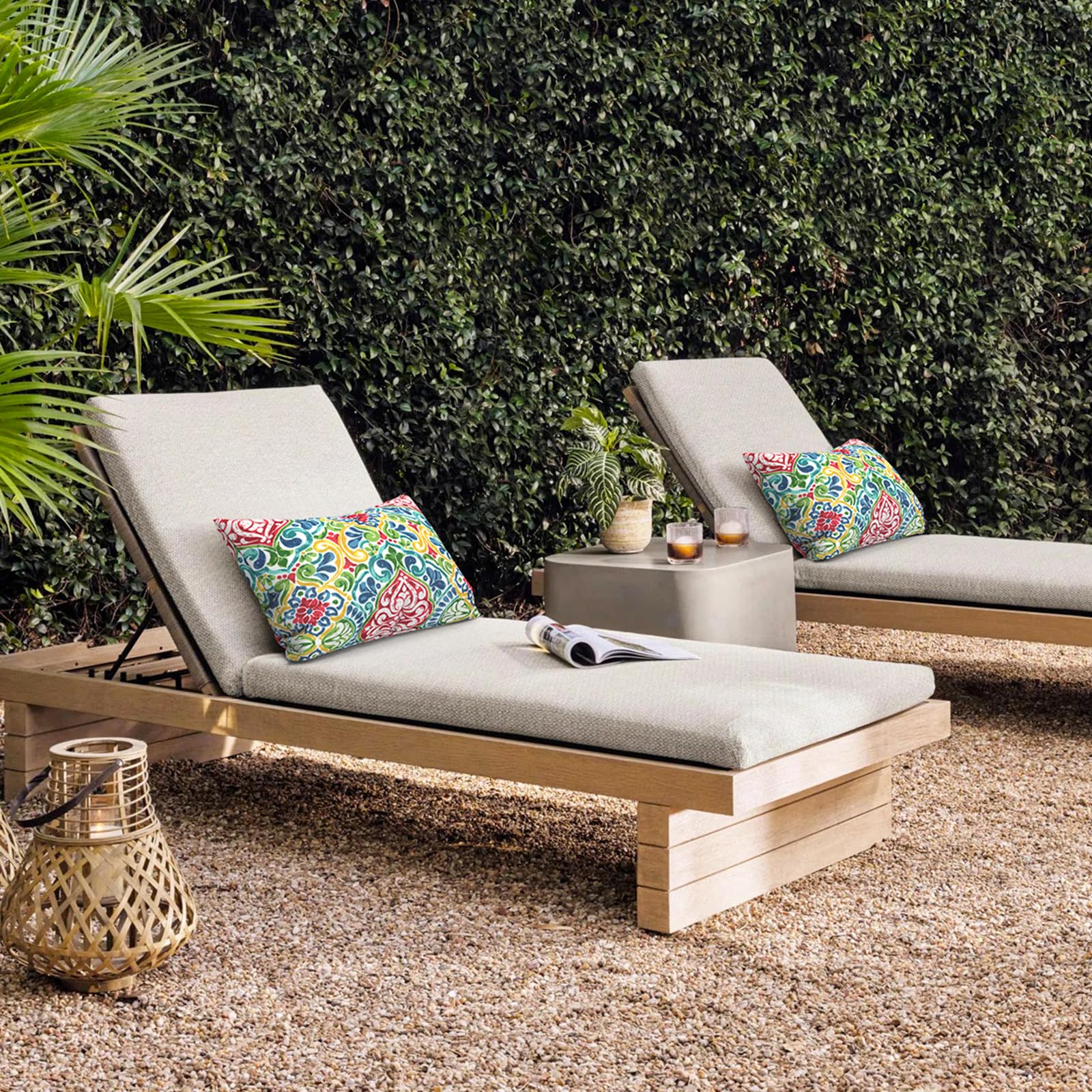 Two outdoor lumbar pillows in a garden setting