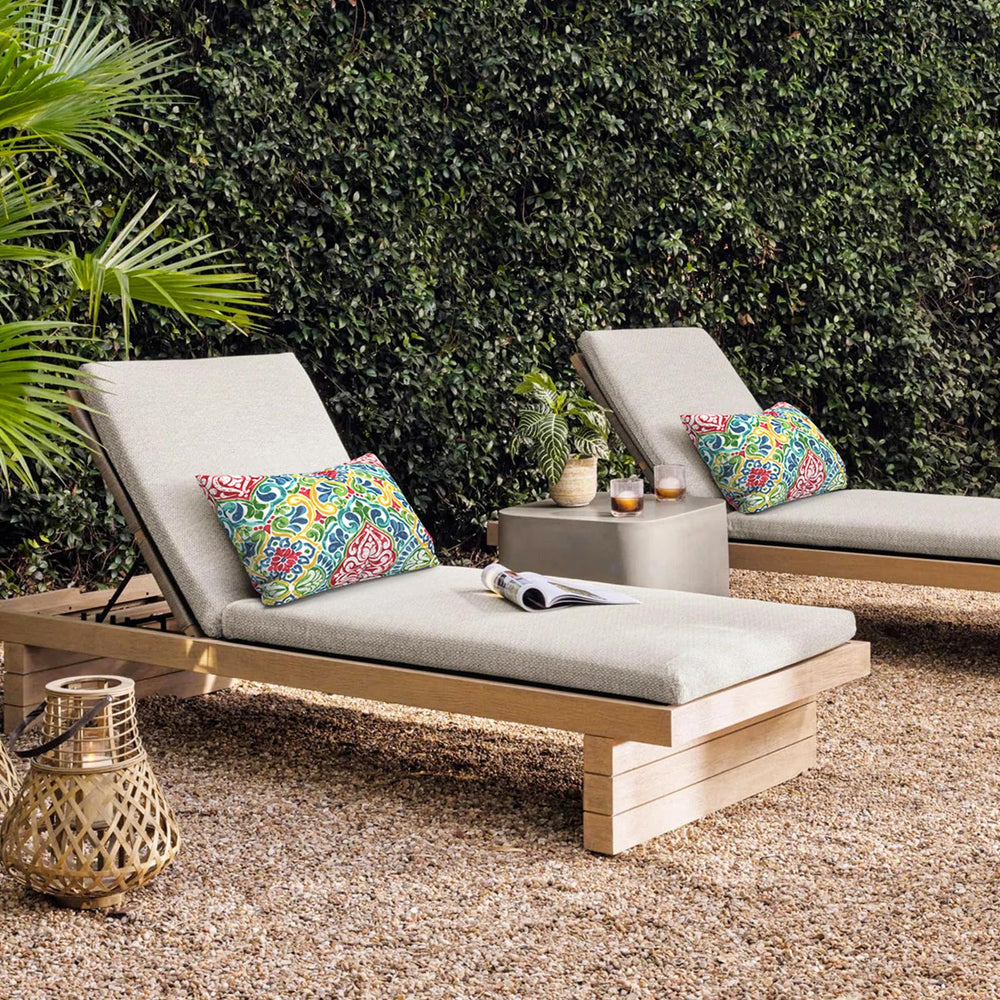 Two outdoor lumbar pillows in a garden setting