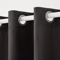 Two panels of TOWN & COUNTRY BASICS Cabana Solid Heavyweight Curtains hanging on a patio